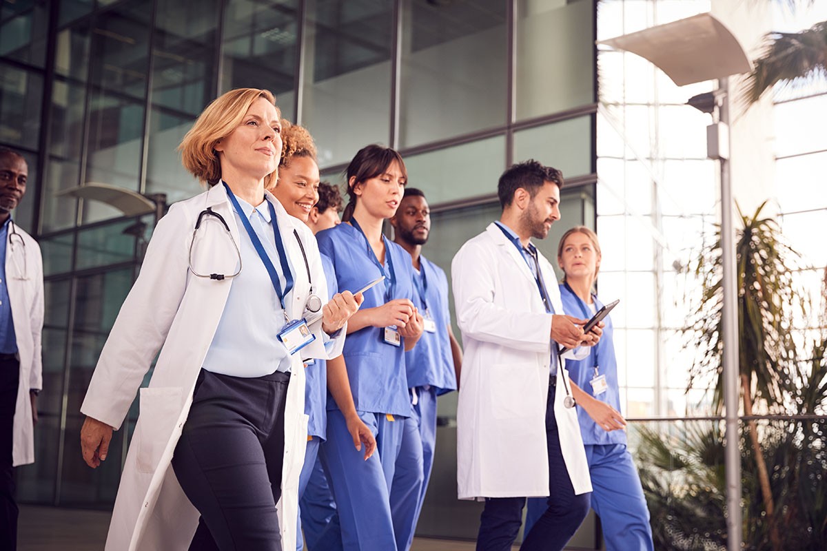 Doctors walking in background of hospital that is equipped with a building management system