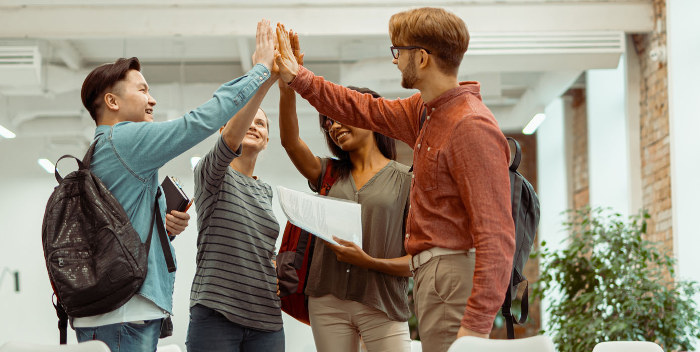 College students high fiving in a library