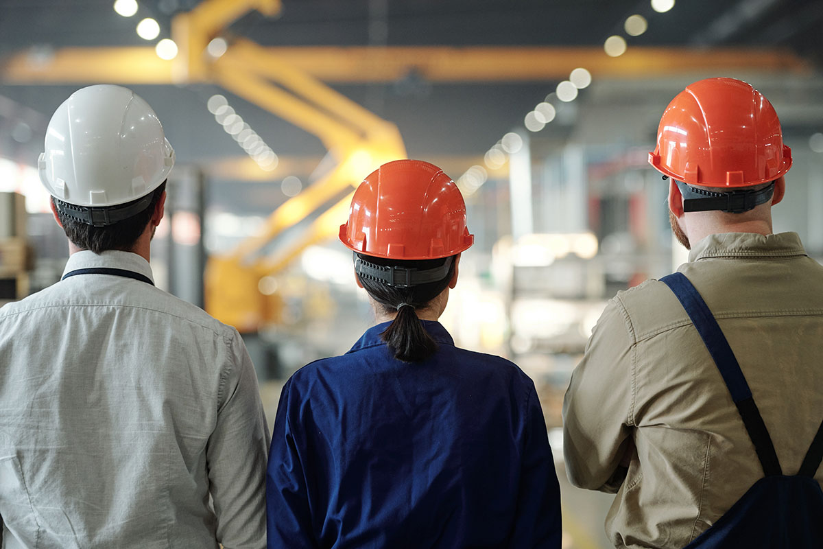 Manufacturing employees in hardhats in a facility equipped with a building automation system